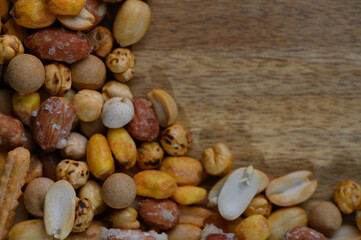 Colorful mix of roasted nuts and snacks beautifully arranged on natural wood background