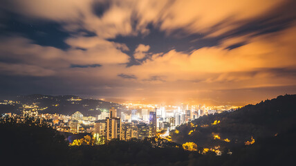 Obraz premium Night cityscape panorama with illuminated city nestled in a valley dramatic cloudscape