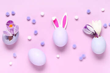 Easter eggs with bunny ears and crocus flowers on pink background