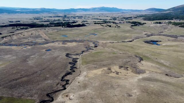 Kupresko polje or Kupres field, Bosnia and Herzegovina. The river flows meanderingly through the field. A winding river in nature, aerial drone view. Meander.