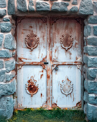 Distressed Metal Double Doors with Ornate Embellishments and Stone Surround