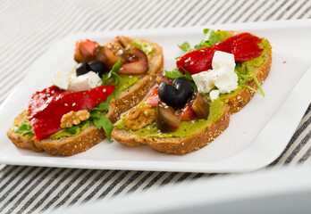 Delicious sandwiches with guacamole, fresh tomatoes, sweet pepper and feta cheese.