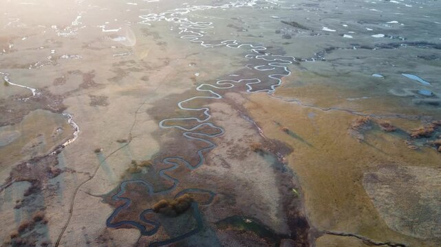 Kupresko polje or Kupres field, Bosnia and Herzegovina. The river flows meanderingly through the field. A winding river in nature, aerial drone view. Meander.