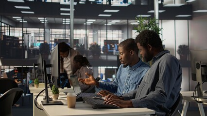 Black corporate team collaborate on global investment strategy, employing their extensive business expertise to work on data driven decisions. Solving administrative tasks for efficiency. Camera B.