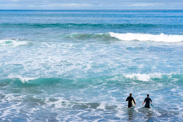 Surfers entering the sea