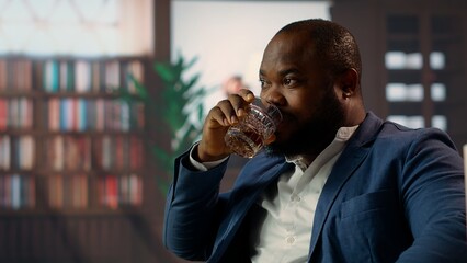 Black gentleman serving a glass of whiskey bourbon at the vintage social club, meeting with friends...