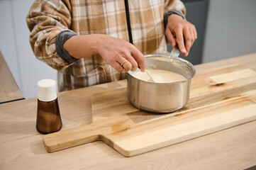 Woman Cooking in Kitchen With Batter on Wood Cutting Board