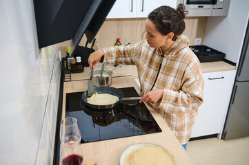 Woman Cooking Crepes in a Modern Home Kitchen