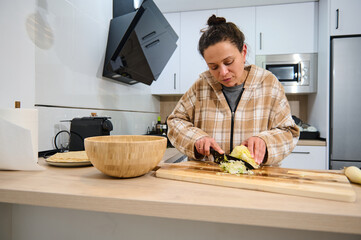 Young Woman Preparing Fresh Salad in a Modern Home Kitchen Setting