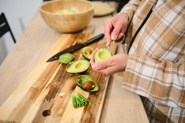 Person Preparing Fresh Avocado for a Healthy Recipe in a Cozy Kitchen