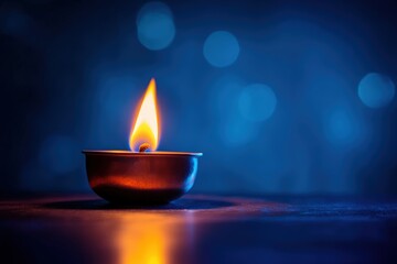 A small candle burns brightly with a warm orange flame