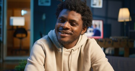 African American adult enjoying the comfort of his loft apartment while working remotely on his...