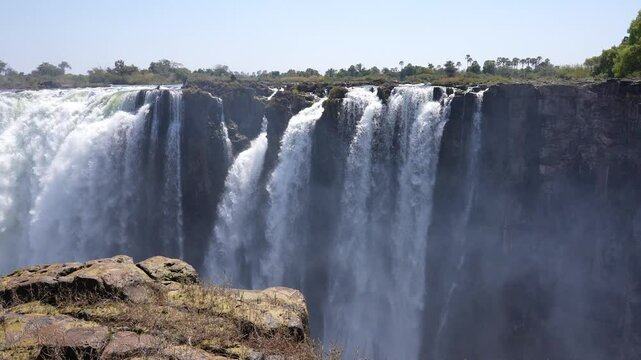 Victoria Falls is a waterfall on the Zambezi River, located on the border between Zambia and Zimbabwe. It is one of the largest waterfalls in the world