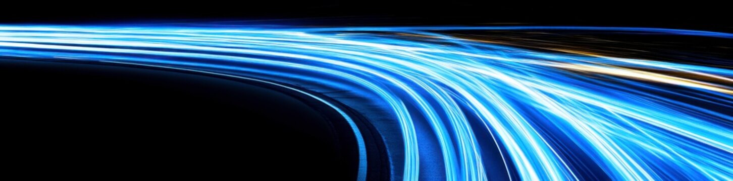 Abstract blue, glowing light speed lines in curved motion on a black background