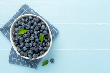 Bowl with fresh bright blueberries on wooden background,top view