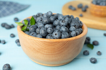 Bowl with fresh bright blueberries on wooden table