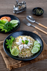 Crab fried rice with cucumber and lime on black plate