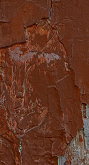 Weathered surface of brown painted surface, with flaking of old paint