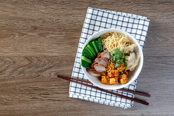 Egg noodle with red roast pork, crispy pork, dumplings, soup and condiments