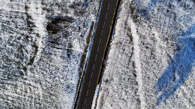 Une route qui travers un champ plein de neige pendant l'hiver