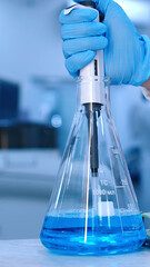 Scientist hand dropping chemical blue liquid into test tube, research and development concept. Pharmaceutical Laboratory. Using Micro Pipette for Mixing Chemicals and Acids. Vertical advertising