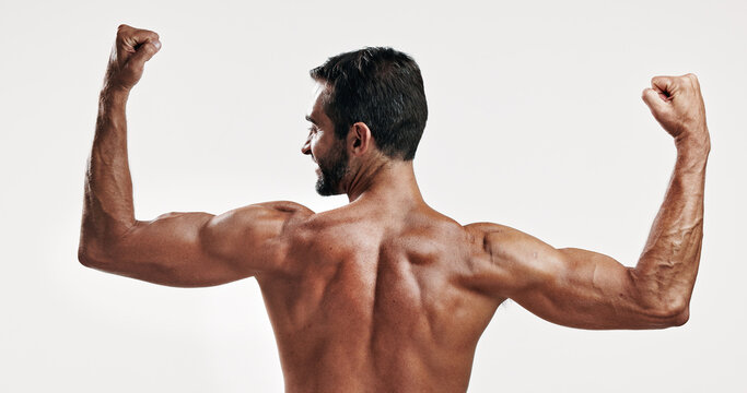 Muscles, strong and back of man flexing in studio with body building workout for fitness progress. Confident, biceps and topless person with strength in arms for power training by white background.