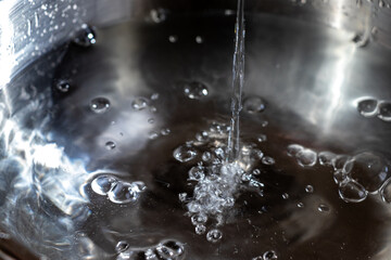 金属の器の中に流れ落ちる水