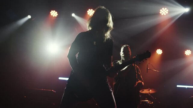 Guitarist performing energetically on stage in slow motion