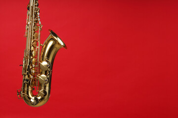Fototapeta premium Jazz. One beautiful saxophone on red background, space for text
