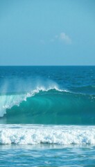 Naklejka premium Rolling waves in the open ocean with a hint of blue turquoise color and white foam on the surface, wave pattern, white foam, blue turquoise