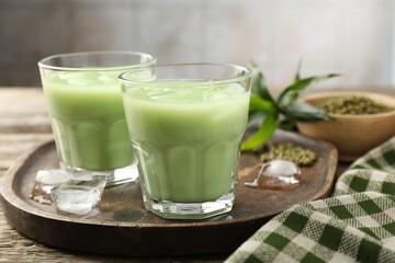 Fresh mung bean juice with ice in glasses on wooden table, closeup