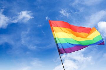 LGBT flag fluttering against beautiful blue sky