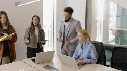 In a modern office, diverse professionals engage in discussions while using laptops, promoting collaboration and boosting productivity for successful project outcomes that benefit all