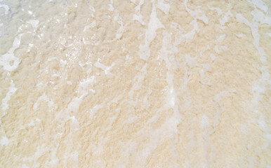 foamy beach water top view