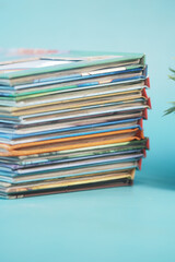 Stack of colorful magazines resting on a light blue surface