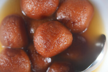 Sweet dessert balls soaked in syrup served in a bowl