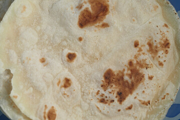 Soft flatbread with golden-brown spots on a blue background