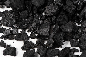 closeup of natural black wood charcoal on white background