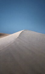 Serene Desert Dunes Against Blue Sky