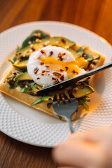 waffles with poached egg avocado on plate on wooden background