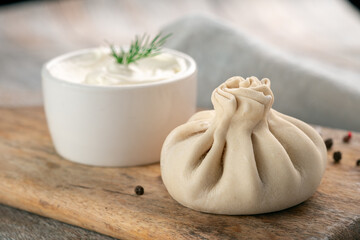 Chinese raw dumplings or Georgian khinkali on a wooden cutting board