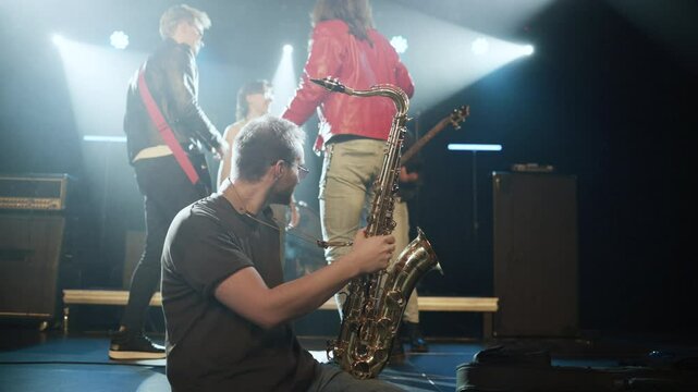 Saxophonist prepares saxophone on stage in slow motion