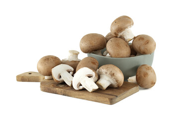 Rustic wooden board displays fresh cremini mushrooms alongside bowl overflowing with earthy delights