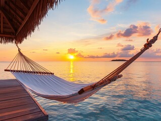 A tranquil hammock swaying by the sea during a stunning sunset.