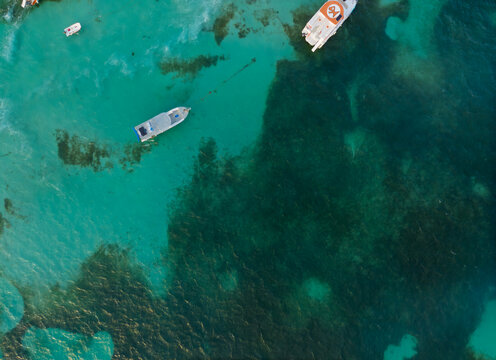 A boat is floating in the ocean with a few other boats in the background