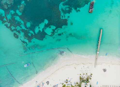 A beautiful blue ocean with a sandy beach and a pier