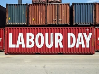 Red shipping container boldly displays Labour Day message under bright sunlight. AI Generated