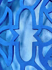 Close up of blue laser cut in random Middle eastern ornamental shape pattern, with light blue background. Suitable for wall pattern decoration panel. Arabic feel. Seamless background texture.