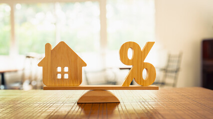 Wooden house model, Percentage symbol on wooden balance with sunlight, Concepts of interest, a...