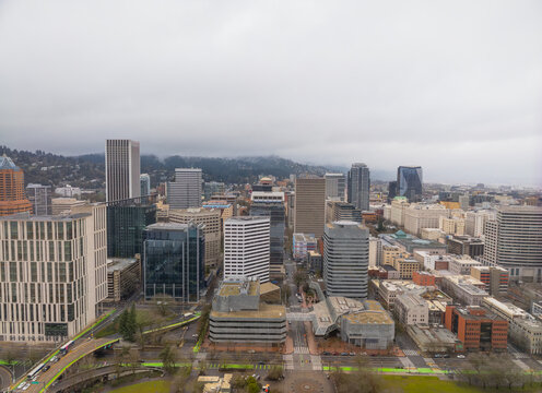 A cityscape with tall buildings and a cloudy sky